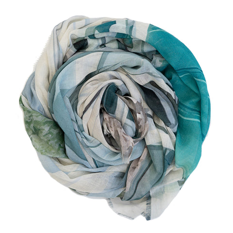 A  scrolled up cotton linen scarf featuring Portsea Beach boatsheds in greens and greys.